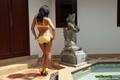 Nuch standing beside swimming pool wearing bikini in high heels